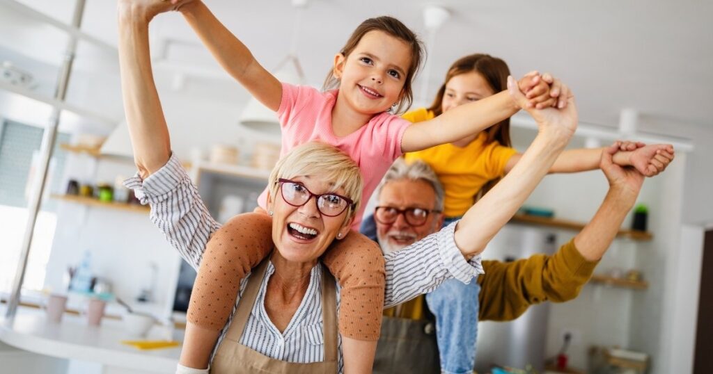Couple carrying children on their shoulders