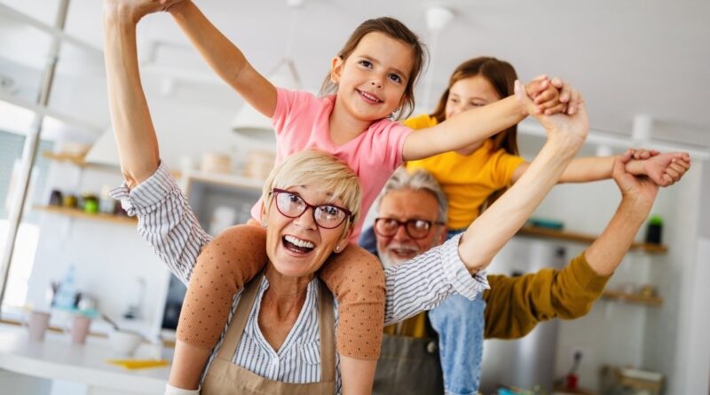 Couple carrying children on their shoulders